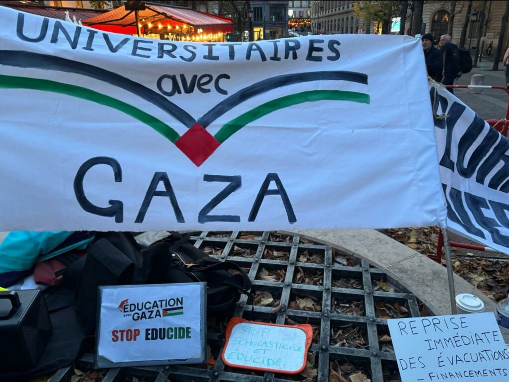Banderoles de manifestation dans le cadre du boycott universitaire : Universitaires avec Gaza et le symbole d'un livre ouvert vers le haut, avec les couleurs du drapeau palestinien pour représenter les pages.